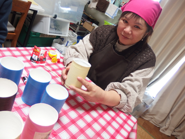 リメ缶を持つ女性の写真。カメラ目線で不敵に微笑んでいる。