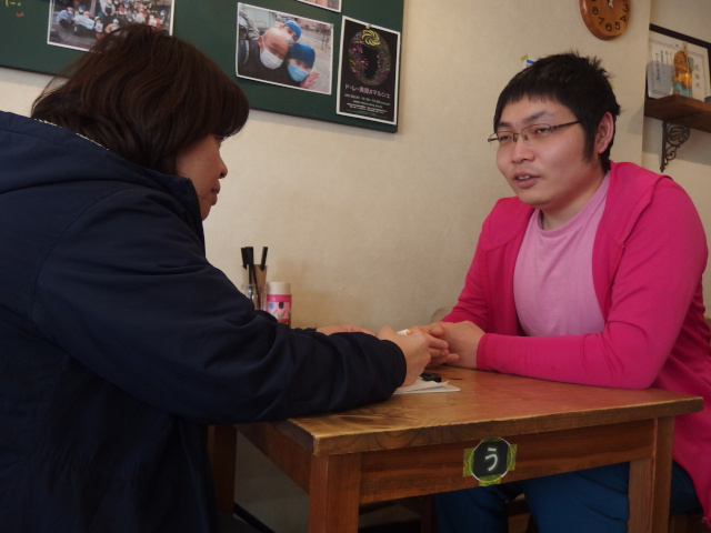 生活相談を受けている。女性スタッフが男性メンバーの相談を受けている。